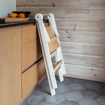Roomix foldable toddler tower next to kitchen counter, showing ideal height for child participation in cooking