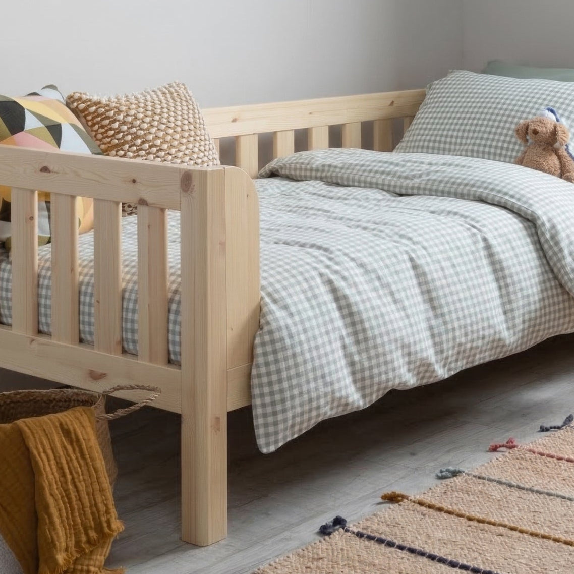 Children's bedroom with a wooden bed, rug, and toys.