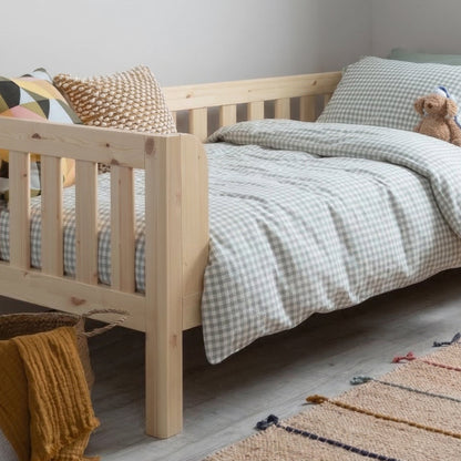 Children's bedroom with a wooden bed, rug, and toys.