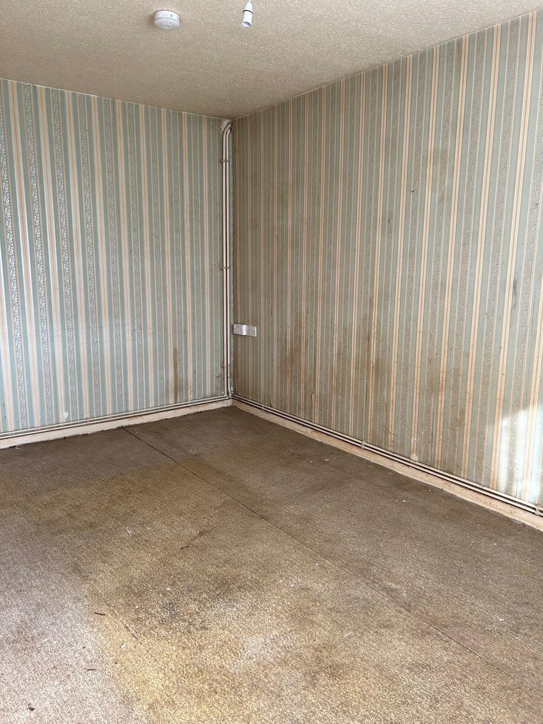 An empty, run-down social housing room before furnishing